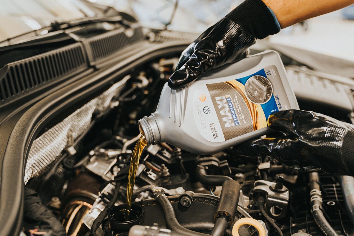Mechanic pouring motor oil into a car engine